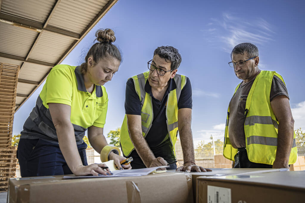 tres personas trabajando sobre papeles
