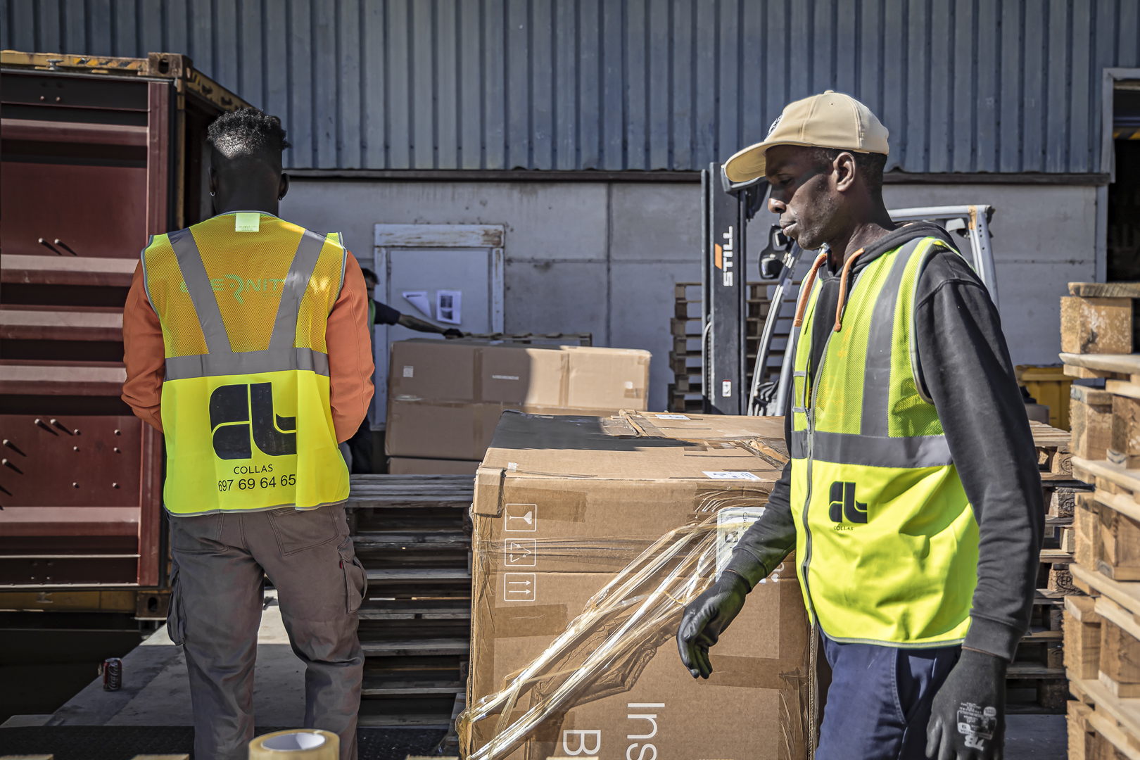 hombres trabajando con cajas al sol