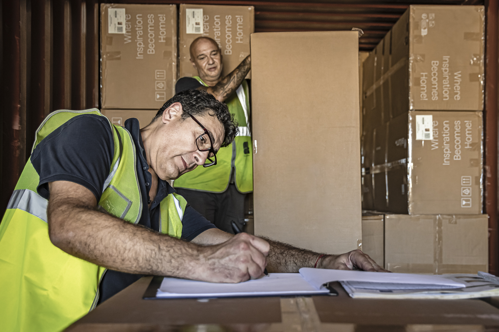 dos hombres revisando cajas en camión