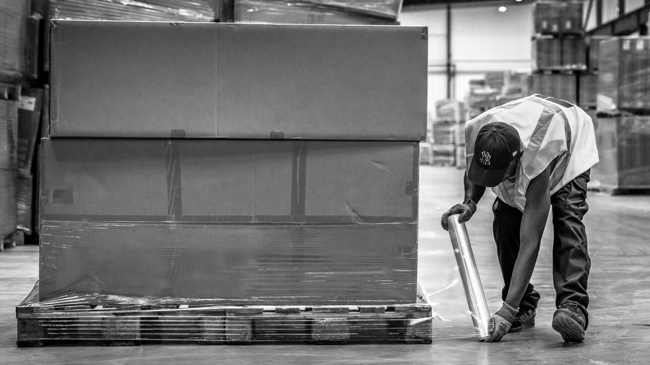 hombre usando film para juntar cajas